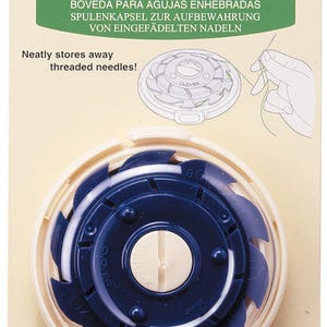 May include: A blue and white plastic dome-shaped needle case with a white label that reads "Clover" and "Art No. 625". The case is designed to store threaded needles.