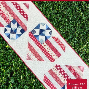 May include: A red, white, and blue quilted table runner with a star-spangled design. The table runner is 23 inches wide and 67 inches long. The pattern includes a bonus 20-inch pillow pattern.