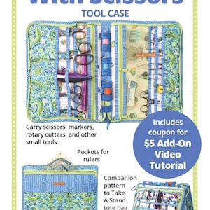 May include: A blue and green fabric tool case with the text "Running With Scissors" and "Tool Case". The case has multiple pockets and compartments for scissors, markers, and rulers. Includes a coupon for a video tutorial.