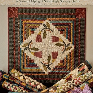 May include: The cover of "Simple Whatnots II" by Kim Diehl features a detailed quilt with floral and geometric patterns in shades of red, green, and cream. Rolled quilts and tools are in a blue wooden box. The book title is displayed at the top.