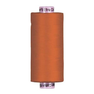 May include: A spool of orange thread, with the text "Efina" and "Cotton 60" visible. The thread is tightly wound, and the spool has a white top and bottom. Ideal for sewing and crafting projects.