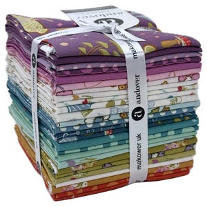 May include: A stack of fabric squares in various colors, including purple, pink, blue, and green, tied with a white ribbon. The fabric features printed patterns of mushrooms, flowers, and other designs. A tag with the text "andover makower uk" is attached.