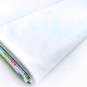May include: White Kona cotton fabric rolled up with the label "KONA" visible on the edge.