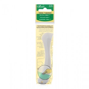 May include: A white plastic tool called a "Hera" marker for marking and making creases simultaneously. The tool is shaped like a rounded spatula with a handle. The packaging is green and yellow with the text "HERA" MARKER in black.