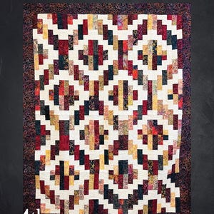 May include: Bonfire quilt pattern, measuring 70" x 90", features a geometric design with rectangular blocks in red, gold, and navy blue on a cream background. The quilt is framed by a patterned border. The text "Bonfire" is at the top.