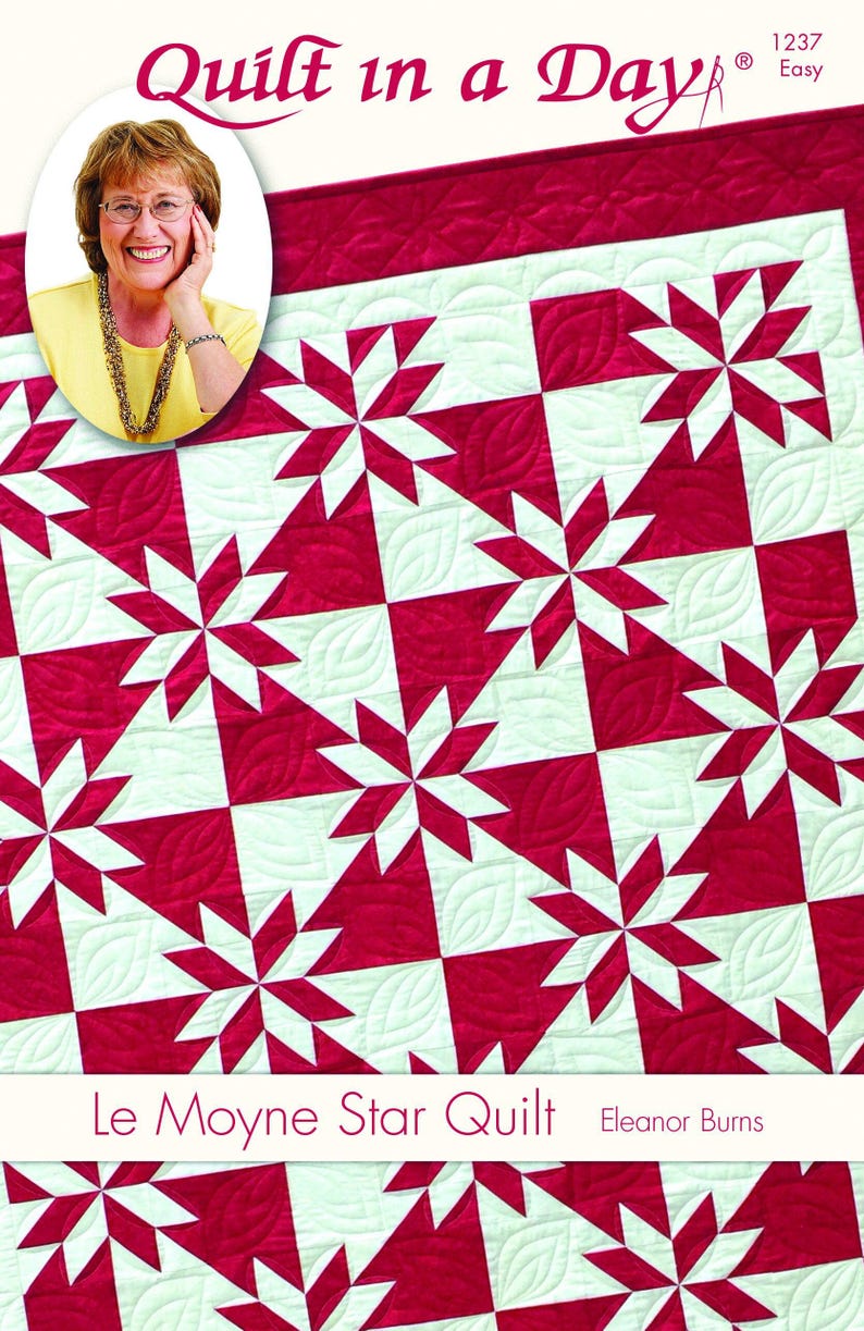 May include: A red and white quilt with a star pattern. The quilt features a repeating design of red starbursts on a white background. The words "Quilt in a Day" and "Le Moyne Star Quilt" are visible.