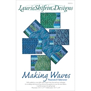 May include: A product advertisement featuring placemats and a tablerunner with a "Making Waves" design. The placemats and tablerunner are made with various blue and green patterned fabrics. The text "Laurie Shifrin Designs" is at the top.