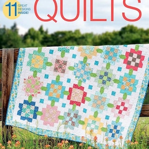 May include: A colorful quilt with a floral pattern, featuring a variety of colors including red, blue, green, and yellow. The quilt is made up of squares and is hanging on a wooden fence. The quilt is surrounded by green grass and orange flowers.