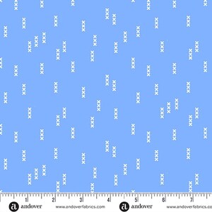 May include: Light blue fabric with a repeating pattern of white 'X' shapes. The fabric has a ruler along the bottom edge with the Andover Fabrics logo and website address. The pattern is evenly spaced across the fabric.