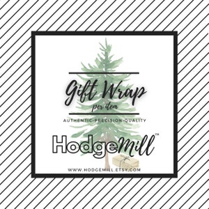 May include: A white square with black borders features a watercolor illustration of a green pine tree with a gift box underneath. The text "Gift Wrap per item" is written in black cursive font above the tree. Below the tree, the text "AUTHENTIC.PRECISION.QUALITY" is written in black. Below that, the text "HodgeMill™" is written in black with a stylized font. The text "www.hodgemill.etsy.com" is written in black below the logo.