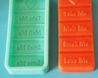 May include: A green silicone mold and a red chocolate bar with the text "Take Me", "Melt Me", "Smell Me", and "Love Me" on each section.