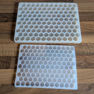Può includere: Due stampi in silicone bianco con un motivo a nido d'ape. Gli stampi sono di dimensioni diverse.