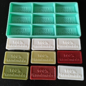 Puede incluir: Un molde de jabón de silicona turquesa con 12 cavidades rectangulares, cada una con el texto "Noor ebembneH" impreso. Debajo, nueve jabones rectangulares blancos, verdes y rojos, cada uno estampado con "100% Handmade".