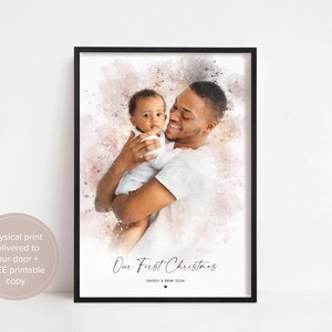 May include: A watercolor-style photo of a father and his baby son. The father is holding the baby in his arms, and they are both smiling. The photo is set against a pink and white background with the text "Our First Christmas" and "Daddy & Remi 2024".