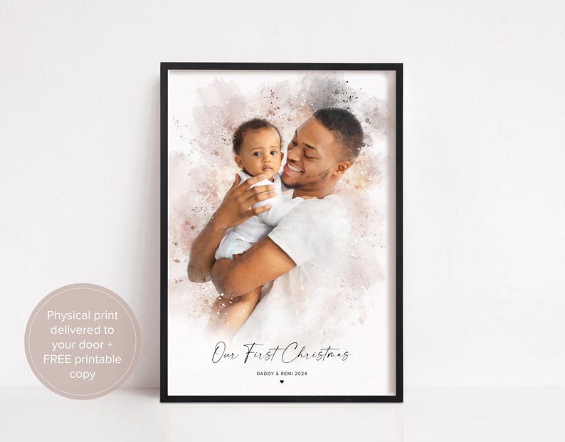 May include: A watercolor-style photo of a father and his baby son. The father is holding the baby in his arms, and they are both smiling. The photo is set against a pink and white background with the text "Our First Christmas" and "Daddy & Remi 2024".