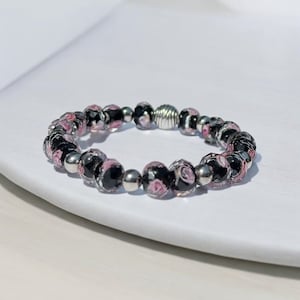 Zwart en roze bloem gefacetteerde glaskralen met zilverkleurige afstandhouders kralenarmband