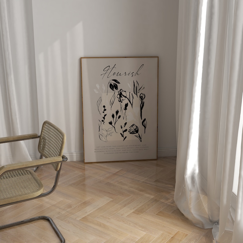May include: A black and white art print with the word "Flourish" in a stylised font. The print features a collection of black floral illustrations on a beige background. The text below the floral illustrations reads "Let God guide you in the garden of your heart.  Let your faith grow, and love inspire.  Let the flowers bloom with fragrant beauty and rain.  Your soul will flourish and never be the same."