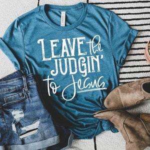 May include: Teal blue t-shirt with white text that reads "Leave the judgin' to Jesus".