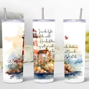 May include: White tumbler with a watercolor illustration of a lighthouse, flowers, and rocks. The tumbler has a quote from John 8:12 that reads "I am the light of the world. He who follows me will not walk in darkness, but will have the light of life."