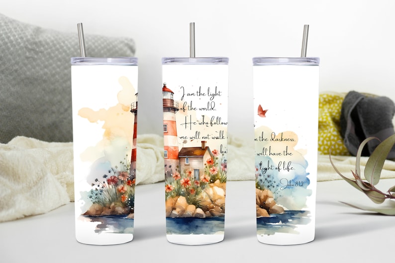 May include: White tumbler with a watercolor illustration of a lighthouse, flowers, and rocks. The tumbler has a quote from John 8:12 that reads "I am the light of the world. He who follows me will not walk in darkness, but will have the light of life."