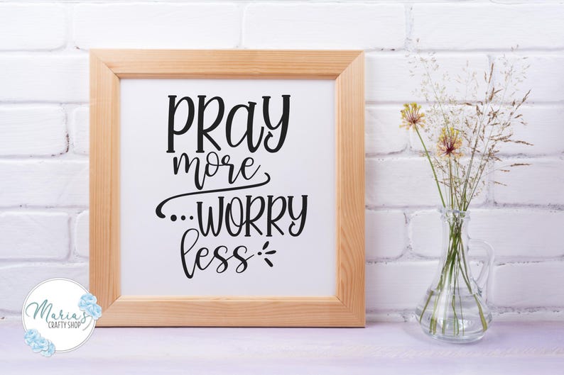 Może przedstawiać: Wydruk w ramie z tekstem "Pray more...worry less" czarnymi literami na białym tle. Rama jest z jasnego drewna, a wydruk leży na białej powierzchni.