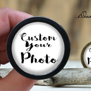 May include: Two round black and gold photo frames with white backgrounds. The text "Custom Your Photo" is printed in black on both frames.