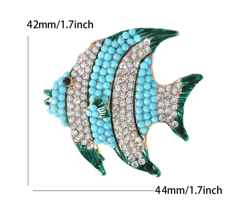 以下が含まれることがあります： 装飾的な魚のブローチ。高さ42mm、幅44mm。ターコイズビーズとクリアクリスタルを使用。魚は緑色のひれと黒い目を持ち、白い背景に配置されています。