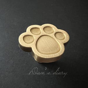 Mässingsknopp i katttass: Guldfärgad barnhandtag till byrå