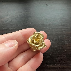 May include: A gold-colored rose-shaped decorative knob.