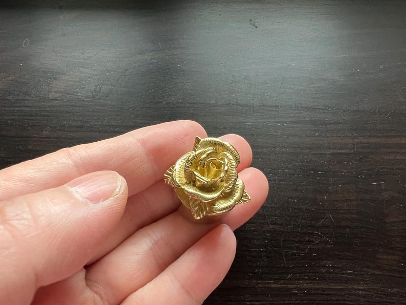 May include: A gold-colored rose-shaped decorative knob.