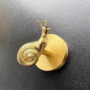 Väggkrok i mässingssnigel: Nordisk kläd-/handdukshängare