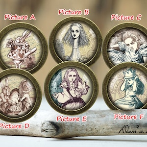 Puede incluir: Seis cabujones redondos de vidrio enmarcados en dorado con imágenes de Alicia en el País de las Maravillas. Las imágenes incluyen la Reina de Corazones, Alicia y el Conejo Blanco.