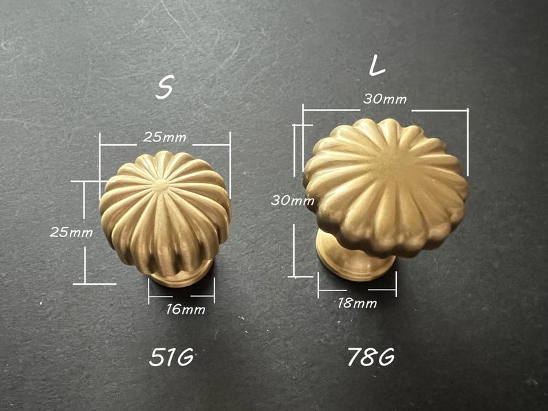 Puede incluir: Dos pomos de armario de color dorado con un dise&ntilde;o acanalado. El pomo m&aacute;s peque&ntilde;o mide 25 mm de di&aacute;metro y 16 mm de alto. El pomo m&aacute;s grande mide 30 mm de di&aacute;metro y 18 mm de alto.