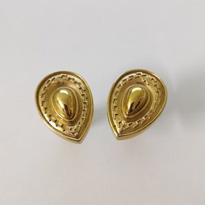 May include: A pair of gold-tone teardrop-shaped earrings with a textured design.