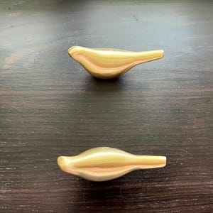 Pu&ograve; includere: Due pomelli per porte a forma di uccello di colore dorato.