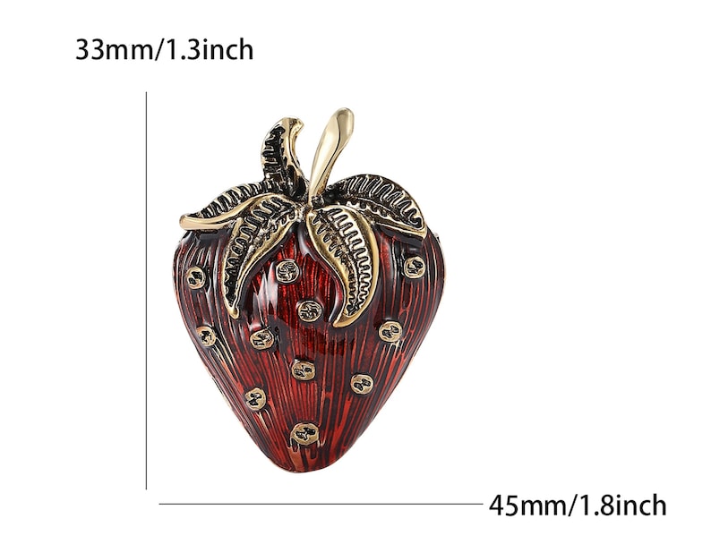 Op de afbeelding: Decoratieve aardbeivormige sieradendoos, rood met gouden details. De doos is 4,5 cm lang en 3,3 cm breed. Het ontwerp omvat gedetailleerde bladeren en een steel. Het oppervlak heeft een textuur met kleine, ronde details.