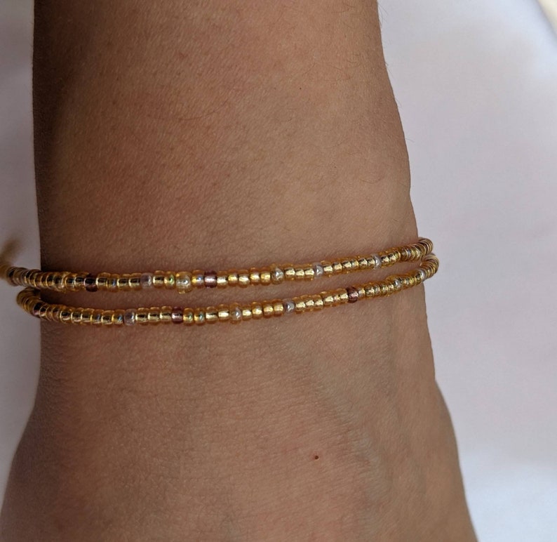 gold bead necklace against skin.