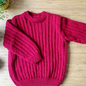 Hand-knitted wool sweater in raspberry 3 years old