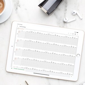 May include: A white tablet with a spreadsheet open on the screen. The spreadsheet is titled "The Time Tracker" and has columns for date, time, task, and notes. The tablet is on a white marble surface with a cup of coffee, a pair of glasses, a white mouse, and a pair of white earbuds.