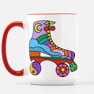 May include: White ceramic mug with a red handle. The mug features a colorful illustration of a roller skate with a rainbow, clouds, and a crescent moon. The wheels have a yin-yang symbol, a flower, and stars.