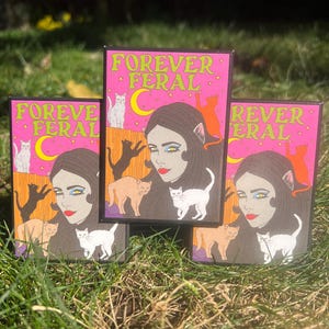 May include: Three pink and black square cards with the text "Forever Feral" in yellow letters. Each card features a woman with cat ears and a variety of cats in different colors.
