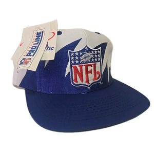 May include: A blue and white NFL baseball cap featuring the NFL logo. The cap has a curved peak and a tag attached to the side. The tag reads "Pro Line Authentic".