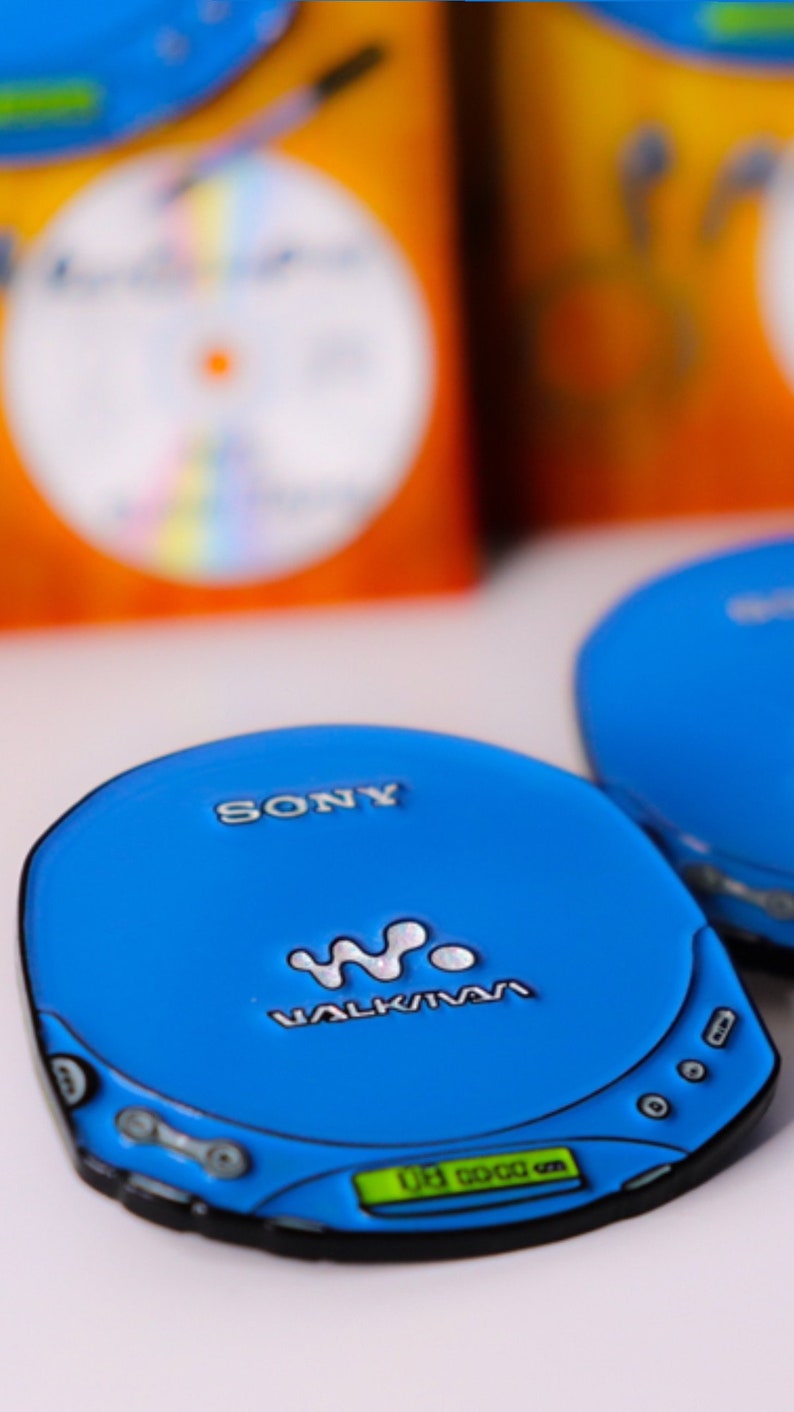 May include: A blue Sony Walkman CD player with a digital display and the text "WALKMAN" on the front.