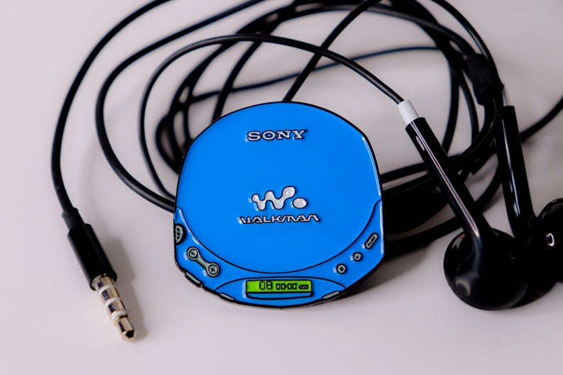 May include: A blue Sony Walkman CD player with a black cord and black headphones. The player has a digital display that reads "00 00 00".