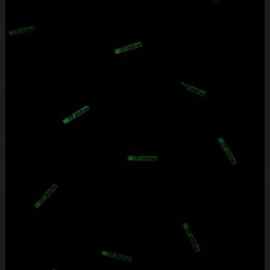 May include: A black background with multiple green glow-in-the-dark stickers that say "100 0000-00".
