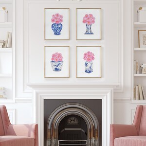 May include: Four framed prints of blue and white porcelain vases with pink flowers. The prints are arranged in a grid on a white wall above a fireplace.