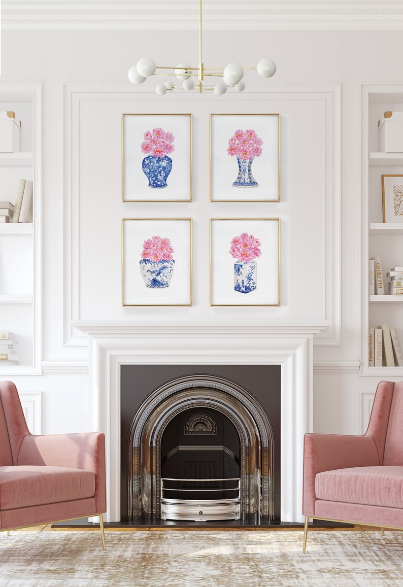 May include: Four framed prints of blue and white porcelain vases with pink flowers. The prints are arranged in a grid on a white wall above a fireplace.