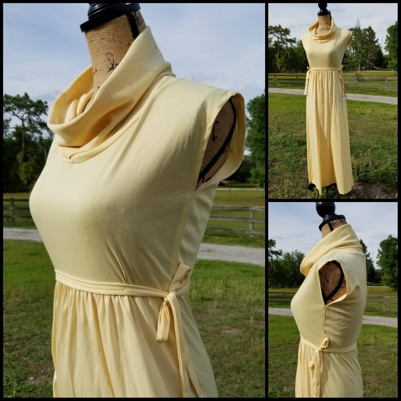 Pode incluir: Um vestido maxi amarelo longo com gola alta e um la&ccedil;o na cintura. O vestido &eacute; sem mangas e tem um design simples e elegante.
