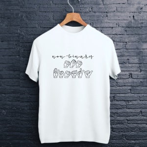 May include: White t-shirt with the text "non-binary" and a sign language interpretation of the word "happy" in black.