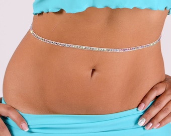 May include: A turquoise crop top with a ruffled hem and a silver rhinestone belly chain.